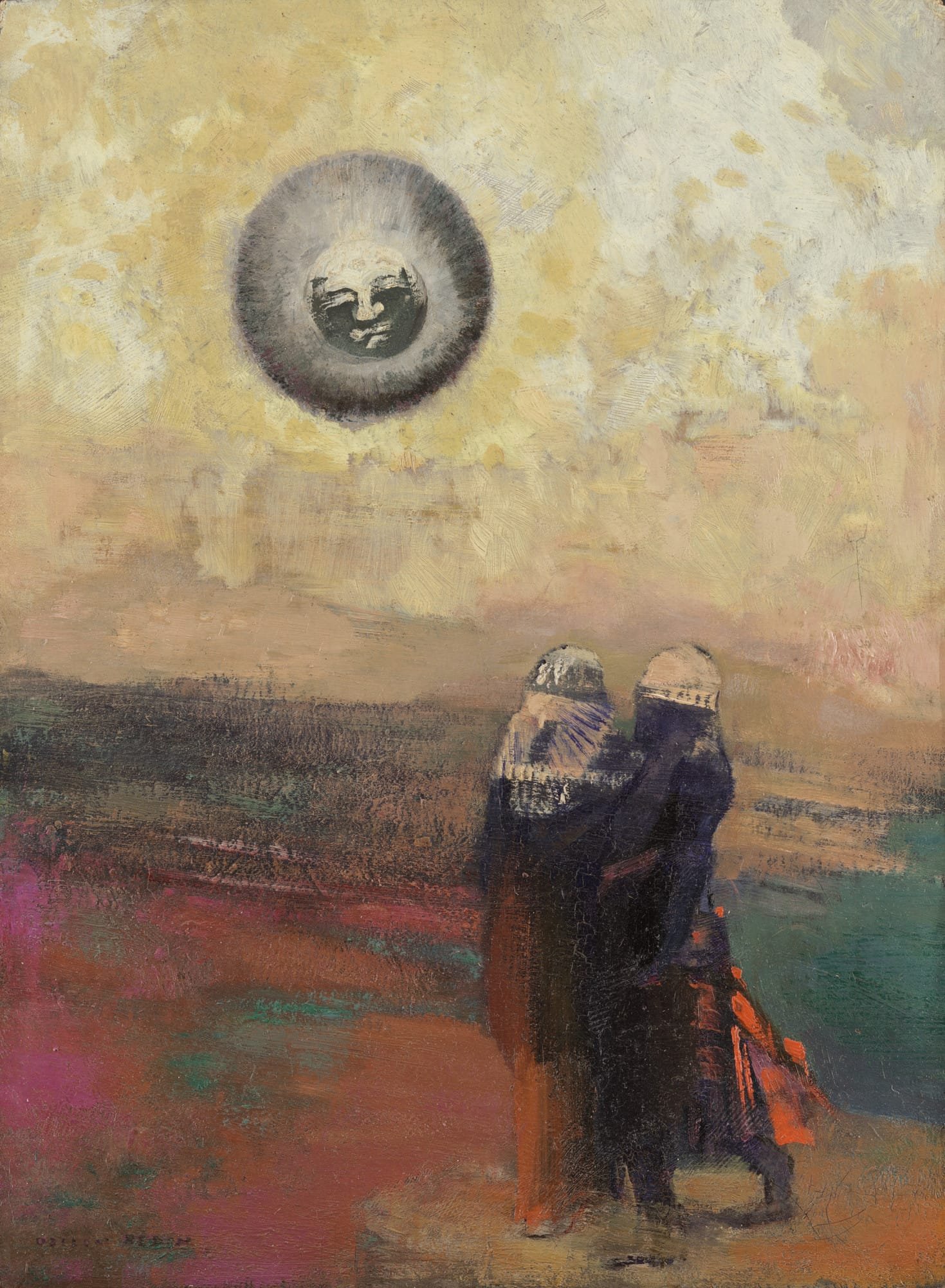 Two cloaked figures stand with their backs to the viewer, gazing up at a dark orb bearing a human face, set against a warm golden sky — Odilon Redon, The Black Sun, c. 1900