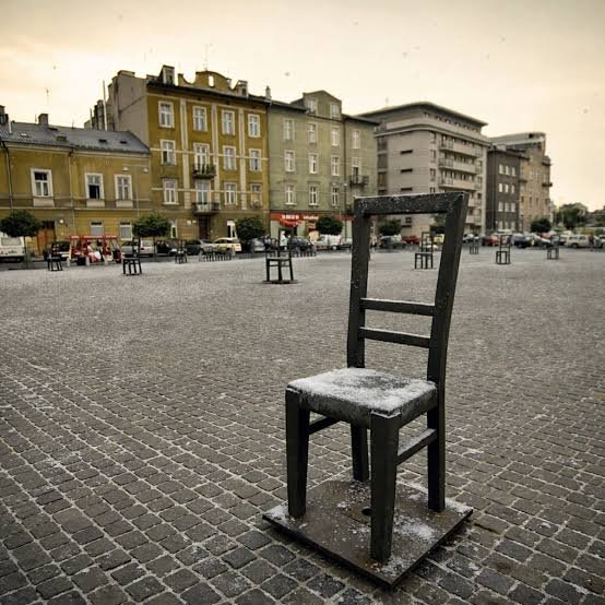 Rows of oversized bronze chairs standing across Ghetto Heroes Square in Kraków